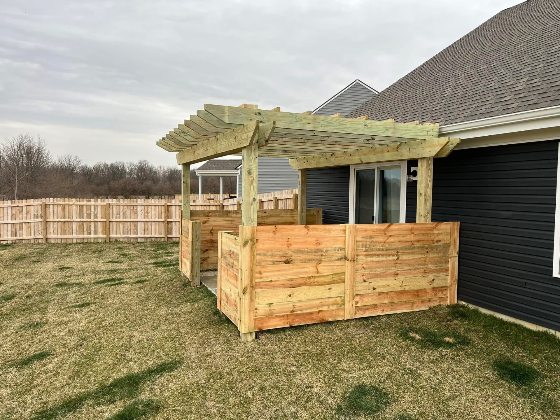 Cedar pergola and horizontal privacy screen beside a home