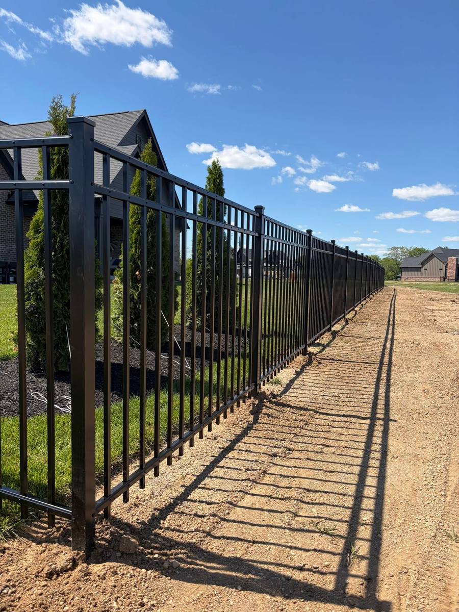 Black aluminum fence line near a new home