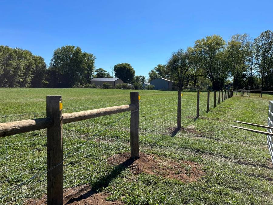 Woven wire farm fence across a pasture