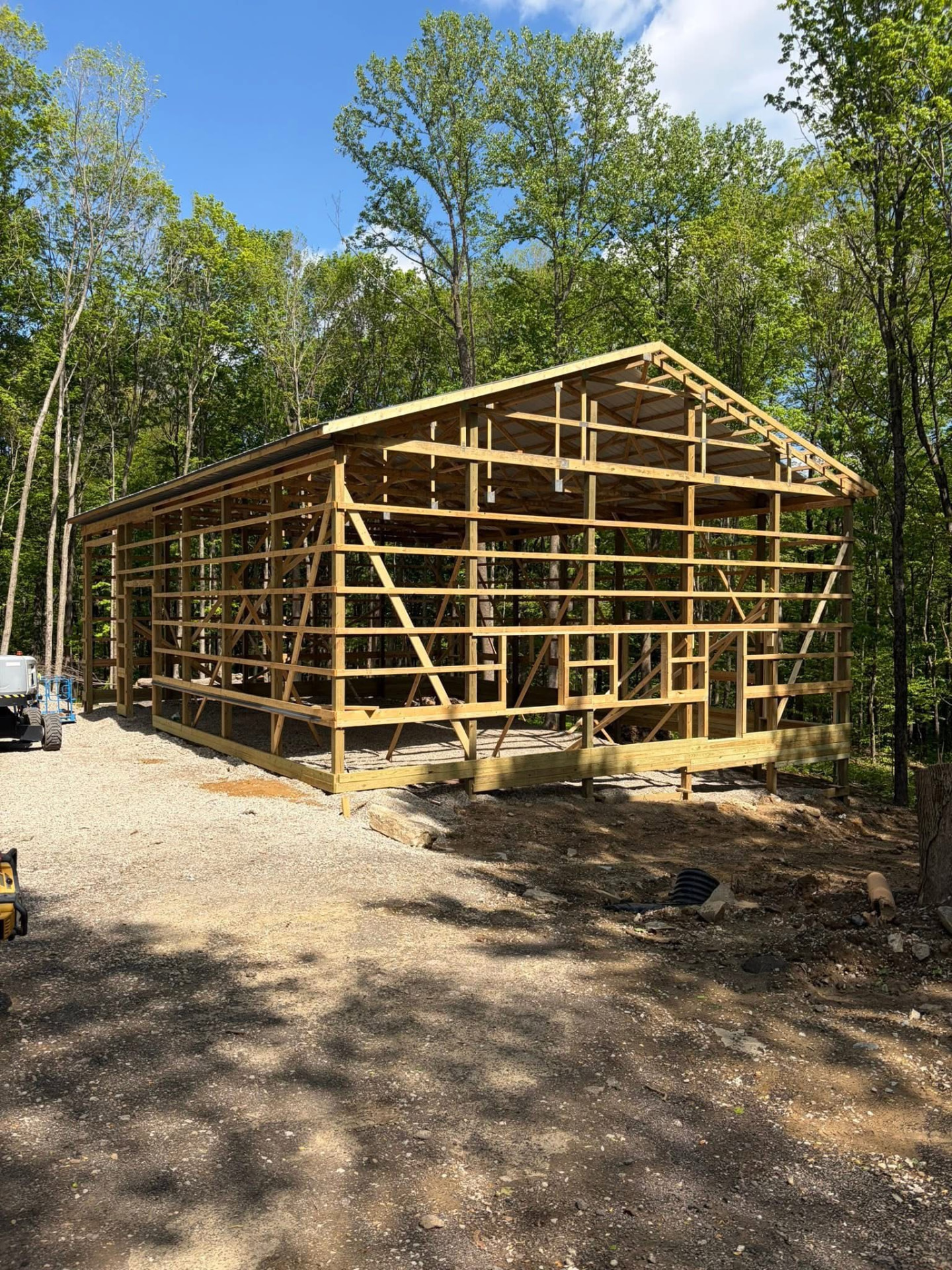 Post-frame pole barn framed up in the woods